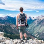 marcheur regardant un point de vue sur une montagne en été