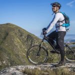 homme sur un VTT en haut d'un montagne en plein été