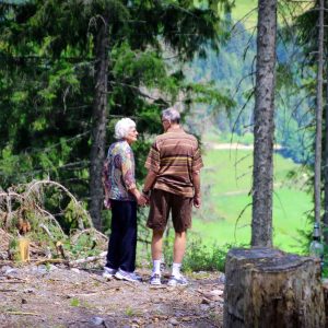 couple de personne âgée qui se balade en forêt pendant la saison été