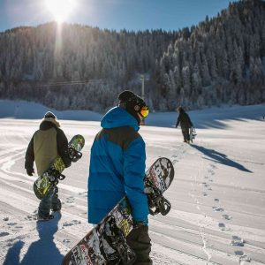 groupe de skieurs en snowboard marchant dans la neige vers la montagne