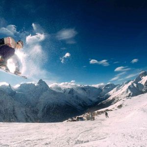 professionnel en snowboard faisant une figure aérienne sur une piste de ski